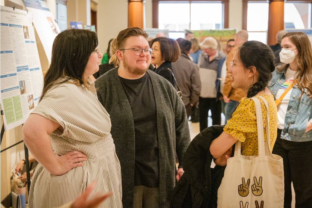 Communications students Bryce and Y talking to Taylor (left)